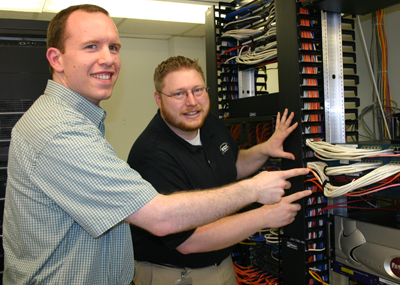 Josh and Jacob from ITS pointing at a server.