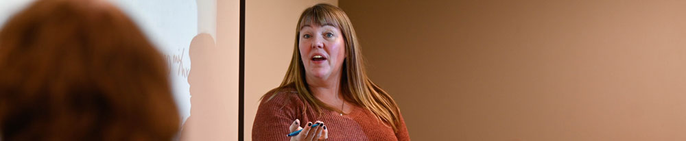 Teacher giving a presentation at the front of a classroom