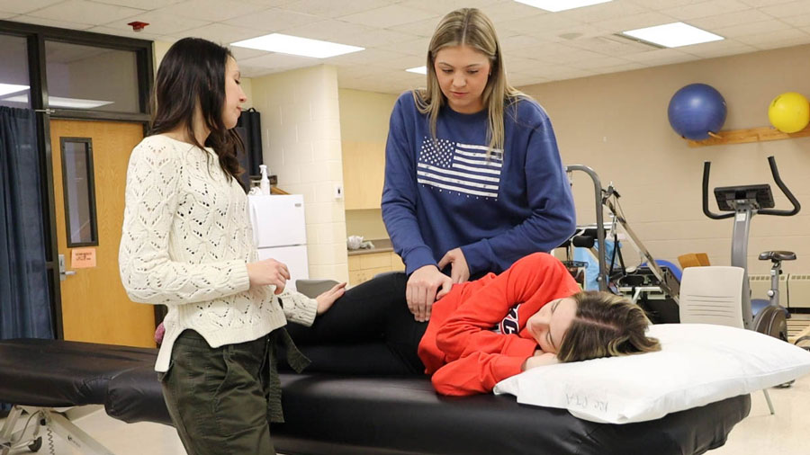 Students doing hands-on trianing in a physical therapy training classroom