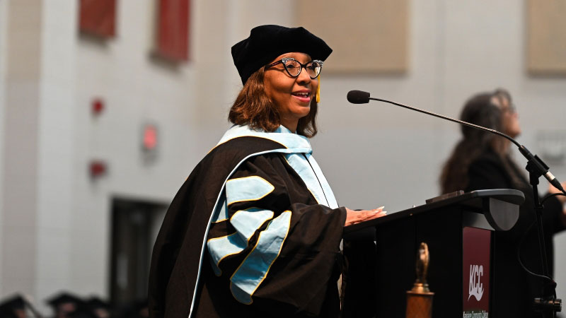Vice President Quincy Sewell in black cap and gowns after commencement ceremony.