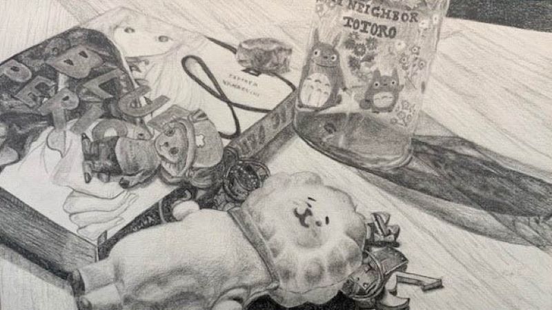 Grey visual of a stuffed teddy bear, book, a toy, and a cup on a table